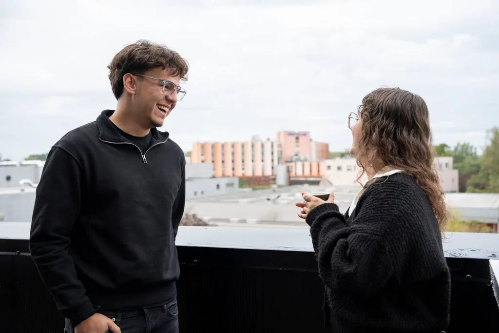 Deux étudiants discutent sur la terrasse du campus