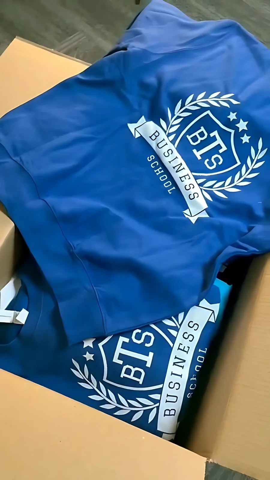 Sweats bleus aux couleurs de l'école, pliés et empilés